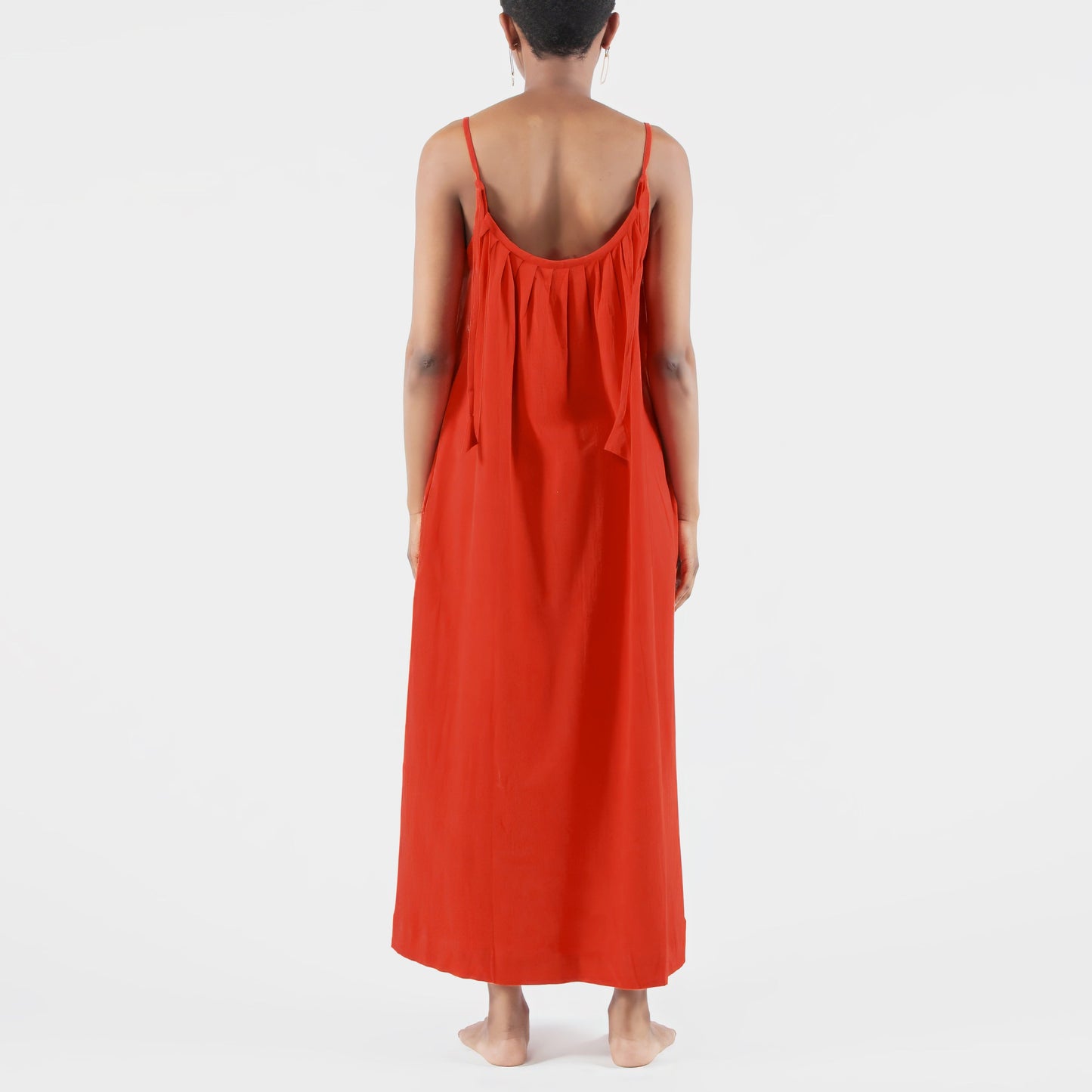 Person wearing a red dress standing in a photo studio 
