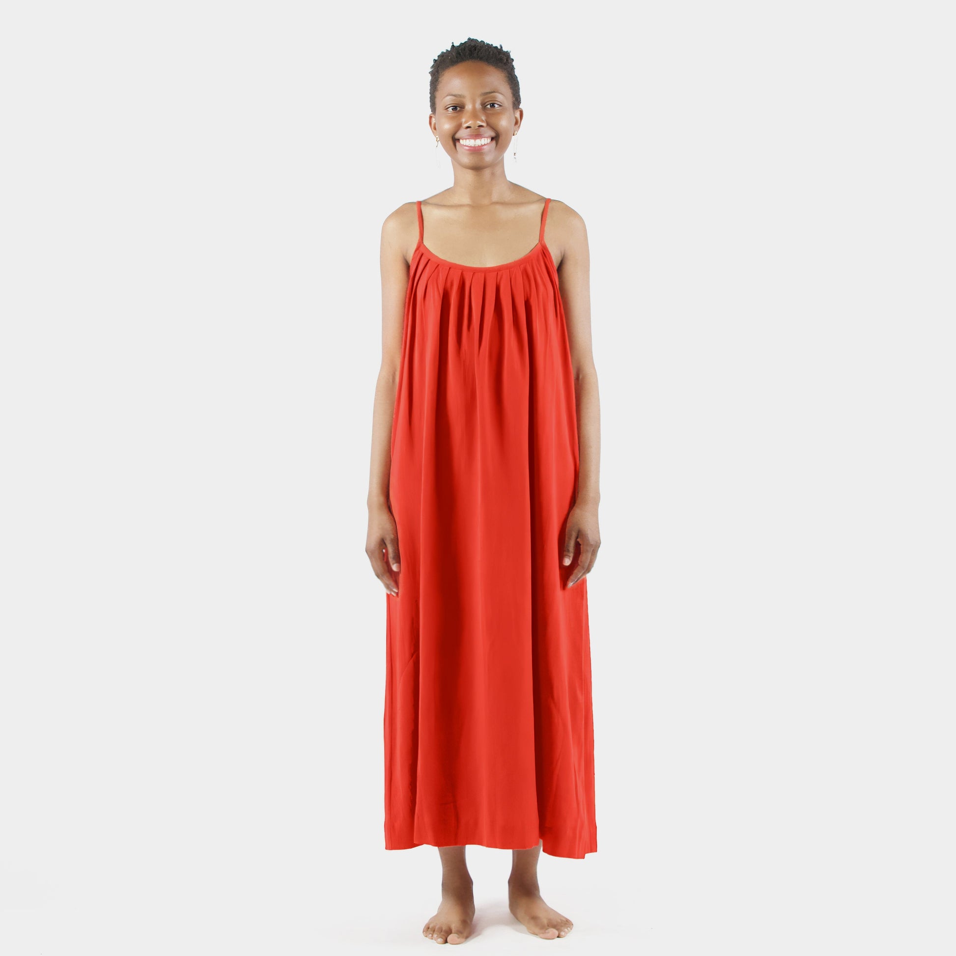 Woman wearing a red dress standing on a white background