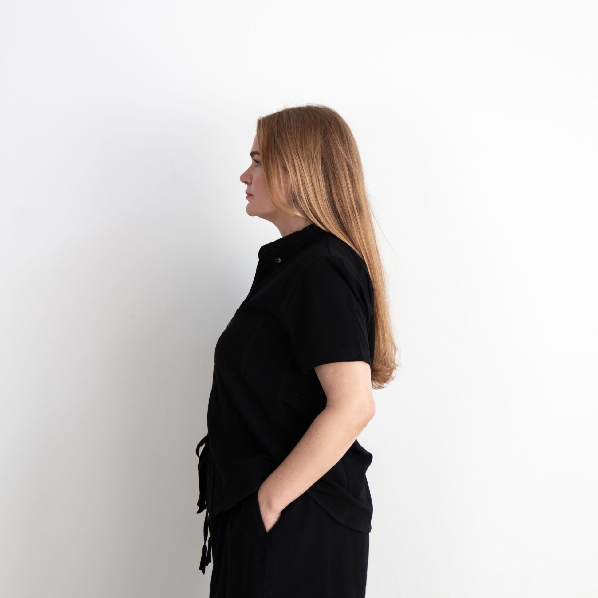 Woman wearing a black outfit against a white background