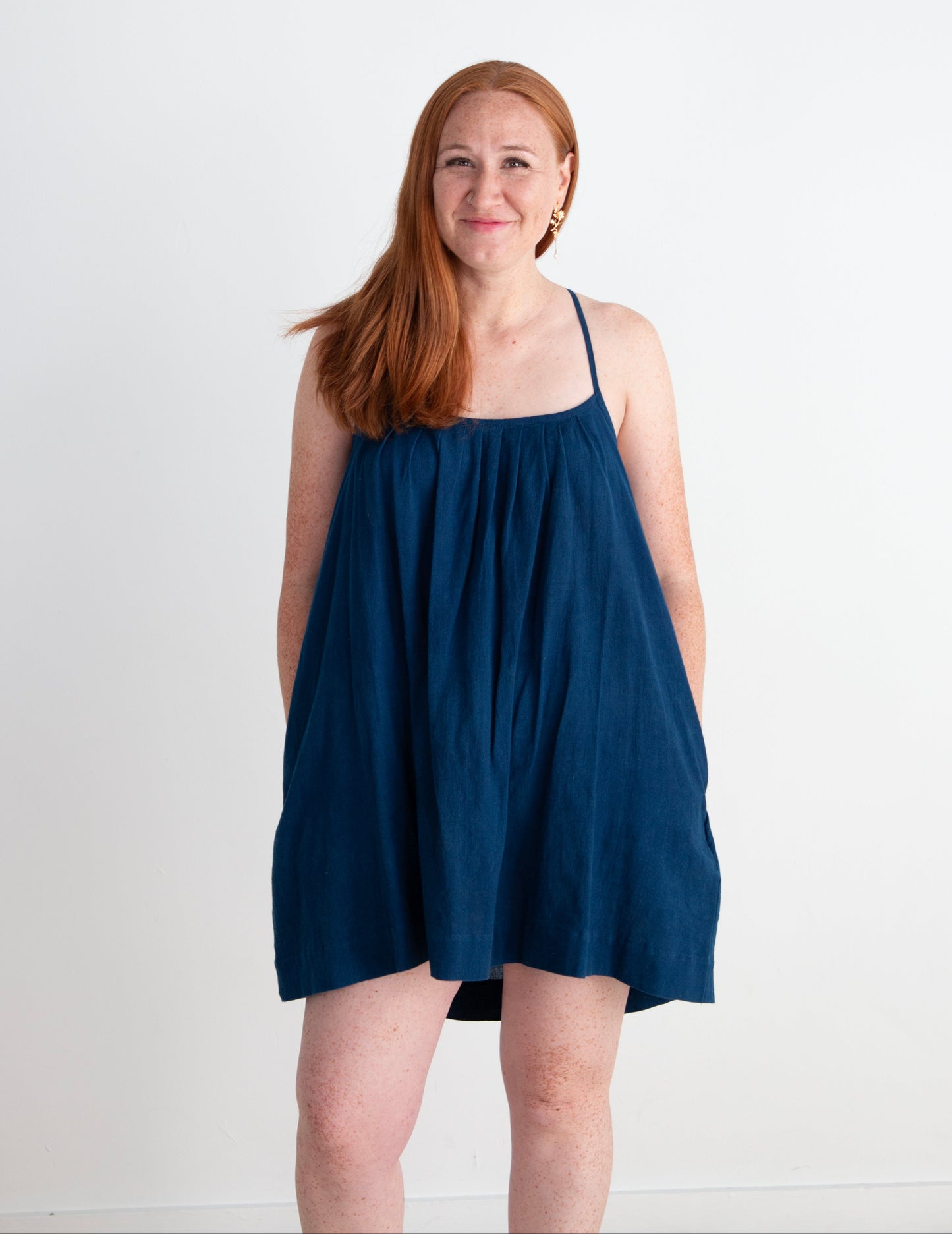 Woman wearing an indigo blue dress against a white background