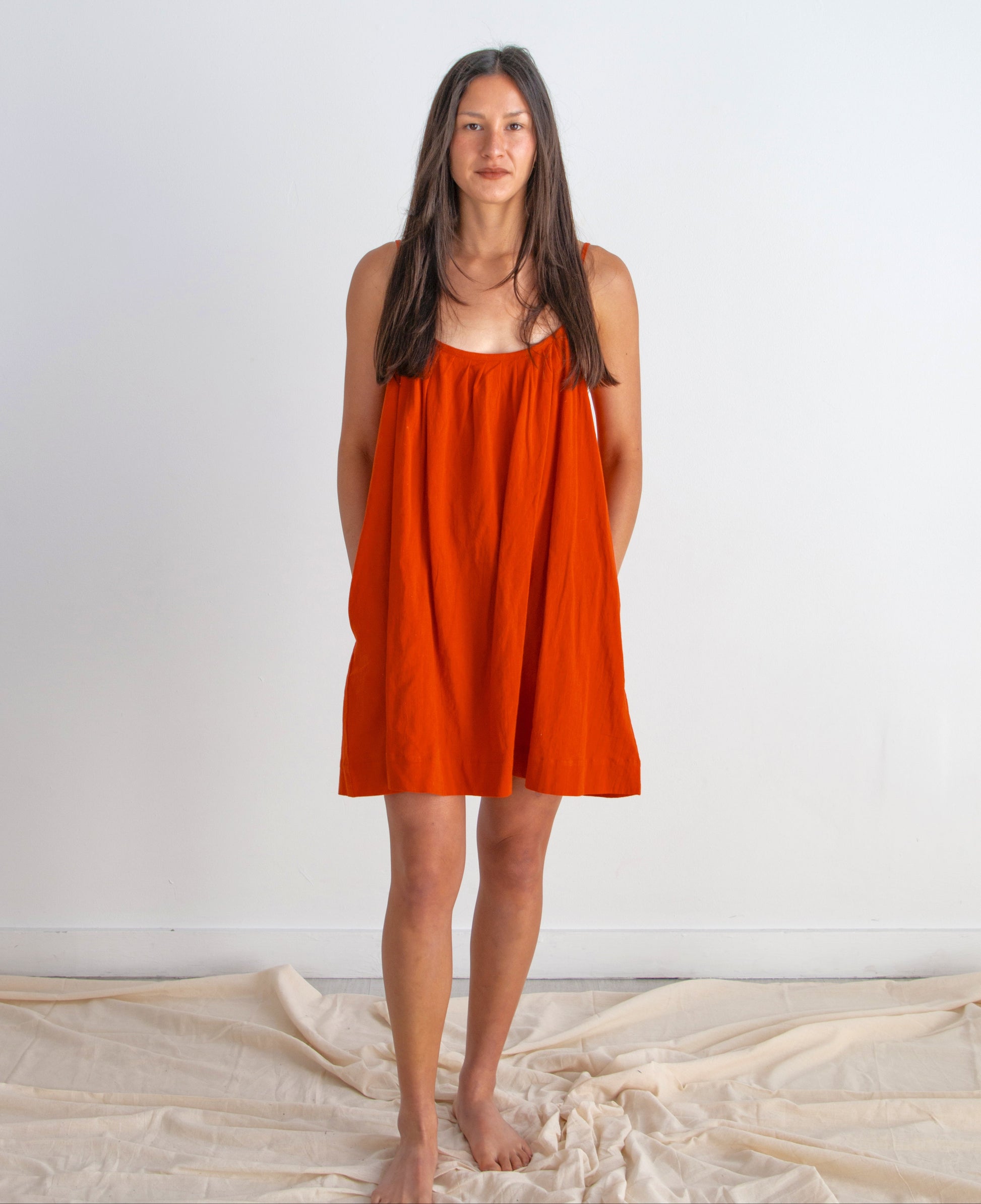 Woman wearing a red dress standing against a white background