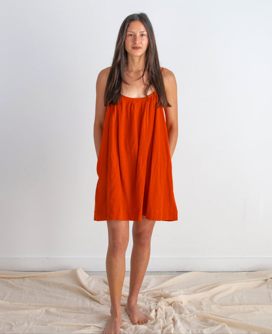 Woman wearing a red dress standing against a white background