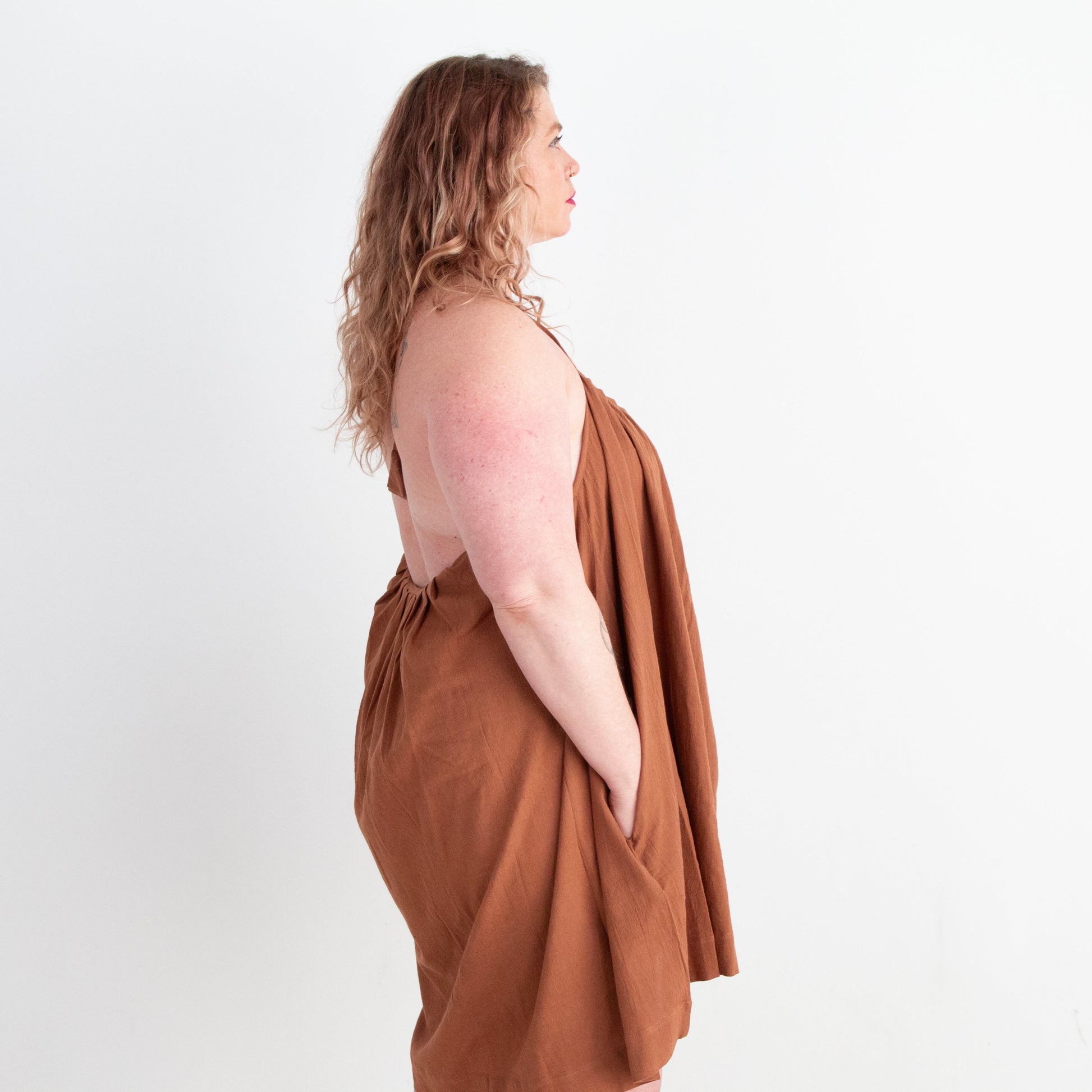 Woman wearing a brown dress against a white background