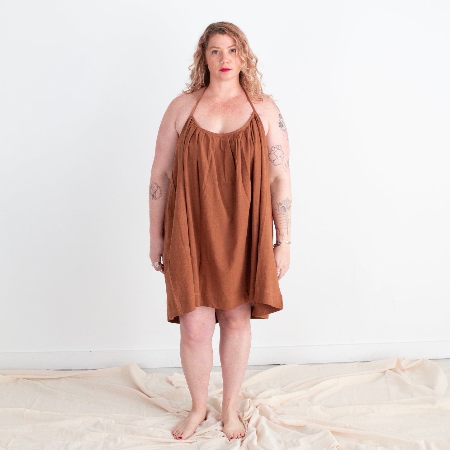 Woman wearing a brown dress standing on a white background